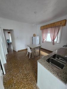 a kitchen with a table and a sink and a table at Casa Blanca Verónica in Veronica
