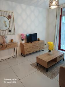 a living room with a tv and a table at Location meublee Kourou pour 5 personnes plus 1 bebe in Kourou
