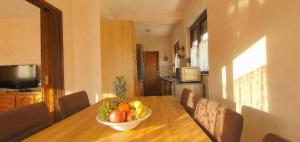 a bowl of fruit on a wooden table in a kitchen at Apartment Novi II in Kaštela