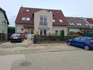 two cars parked in front of a house at Soproniutas Ikva Apartman in Sopron