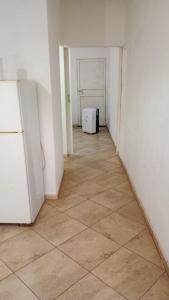 an empty room with a refrigerator and a tile floor at El Amuleto in Rivadavia