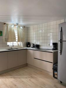 a kitchen with white counters and a refrigerator at Kelly's Vacation Nest to Relax and Reactivate in Willemstad