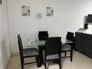 a dining room with a glass table and chairs at Apartamento Albergue - Buga in Buga