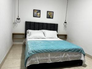 a bed in a room with two pictures on the wall at Apartamento Albergue - Buga in Buga