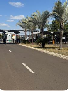 an empty road with palm trees and a building at apartamento Seminate 2 in Franca