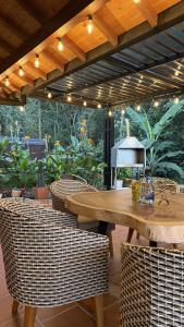 a patio with a wooden table and wicker chairs at Condominio Entre Bosques Cabaña 9 in Piedecuesta