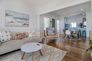 a living room with a couch and a table at Palms on Wunda in Sussex Inlet
