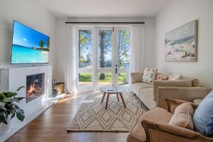 a living room with a couch and a fireplace at Palms on Wunda in Sussex Inlet