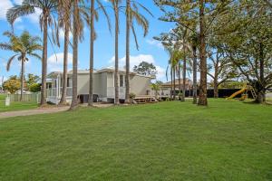 a house with palm trees and a playground at Palms on Wunda in Sussex Inlet