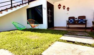 two chairs sitting on the grass near a house at Alojamiento en Tambaca, Tamasopo SLP in Tambaca