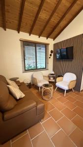a living room with a couch and chairs and a tv at Condominio Entre Bosques Cabaña 9 in Piedecuesta