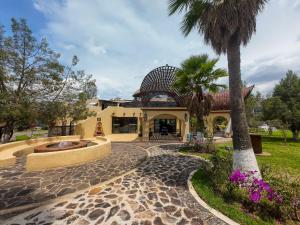 a house with a palm tree in front of it at SANTA CECILIA LA MORA HUASCA in Huasca de Ocampo