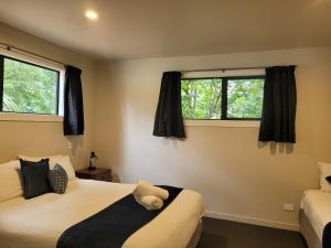two beds in a room with two windows at Fairlie Holiday Park in Fairlie