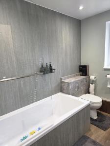 a bathroom with a tub and a toilet at Charming three bedroom house in Durham in Brandon +40 photos