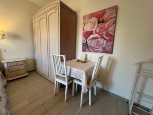 a dining room with a table and chairs and a painting at Monolocale Pink Borgo Roma GB Rossi friendly Verona in Verona +8 photos