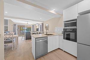 a kitchen with white appliances and a dining room at Family Friendly 2 Bed Flat with Balcony in Mooloolaba