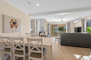 a living room with a table and chairs and a couch at Family Friendly 2 Bed Flat with Balcony in Mooloolaba