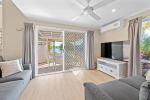 a living room with a couch and a tv at Family Friendly 2 Bed Flat with Balcony in Mooloolaba +9 photos