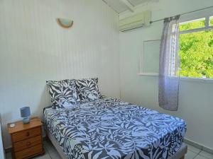 a bedroom with a bed and a window at Maison Désirée in Sainte-Anne