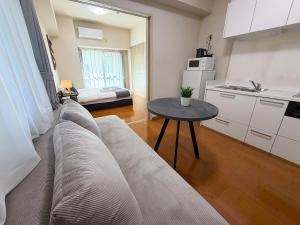 a living room with a couch and a table at OUCHI HOTEL Peace Memorial Park in Hiroshima