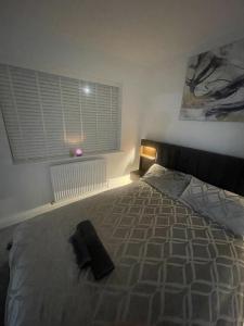 a bedroom with a bed with a black pillow on it at blackburn home in Blackburn