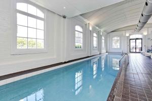 a swimming pool with blue water in a building at QV Stays Modern Spacious Multi-Level Townhouse in Auckland