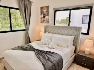 a bedroom with a large white bed with windows at Punta Cana Retreat in Punta Cana +26 photos