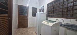 a kitchen with a sink and a refrigerator at Canto dos Pássaros in Brasília