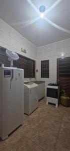 a kitchen with white appliances in a room at Canto dos Pássaros in Brasília