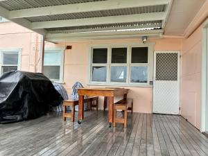 a wooden table and two chairs on a patio at Peach Me Beach Shack in Boat Harbour