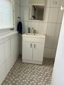 a white bathroom with a sink and a mirror at Peach Me Beach Shack in Boat Harbour +11 photos