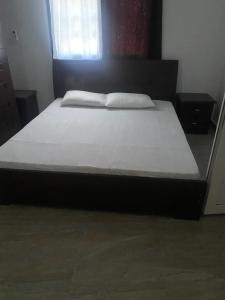 a bed in a bedroom with a white bedsheet at Amie's Villa Apartment in Jarbang