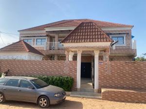 a car parked in front of a brick house at Amie's Villa Apartment in Jarbang