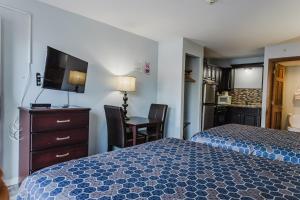 a hotel room with a bed and a desk and a television at Jackson Town House Inn in Jackson +2 photos