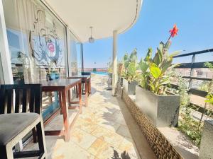 a patio with tables and plants on a balcony at La Renaissance hôtel Marrakech in Marrakesh