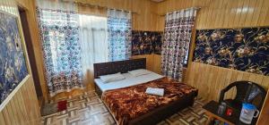 a bedroom with a bed and a window with curtains at Hotel First Kashmir in Srinagar