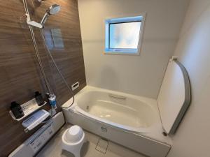 a bathroom with a shower and a bath tub at Villa Aso Otohime in Uchinomaki