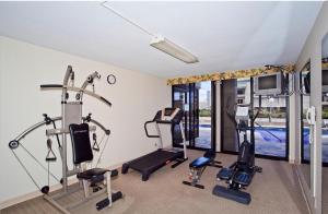 a fitness room with cardio equipment and a swimming pool at Penthouse unit at Palms Waikiki in Honolulu