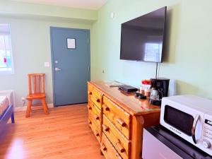 a kitchen with a microwave on a wooden dresser at The Kingsley Suites in Kingsley