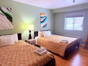 a hotel room with two beds and a window at The Kingsley Suites in Kingsley