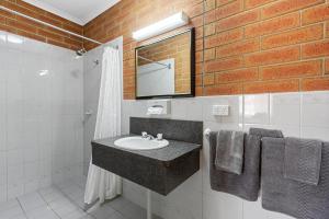 a bathroom with a sink and a brick wall at Edithburgh Seaside Motel in Edithburgh +9 photos