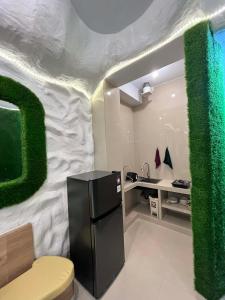 a kitchen with a black refrigerator and a green wall at Amed Sea Resort in Amed