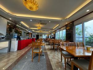a restaurant with wooden tables and chairs and a counter at Sunny Hotel 1 in Hanoi