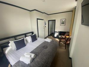 a bedroom with a large bed with towels on it at The Old Railway Hotel Lumsden in Lumsden