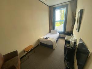 a small room with a bed and a window at The Old Railway Hotel Lumsden in Lumsden