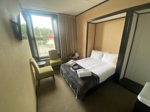 a hotel room with a bed and a chair and a window at The Old Railway Hotel Lumsden in Lumsden +22 photos