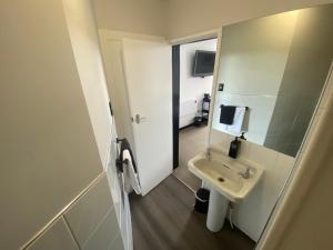 a small bathroom with a sink and a mirror at The Old Railway Hotel Lumsden in Lumsden
