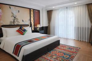 a bedroom with a large bed and a rug at Anara Sapa Hotel & Coffee in Sapa