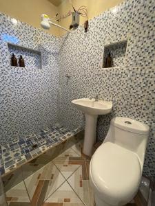 a bathroom with a white toilet and a sink at Zu Suites in San Marcos La Laguna