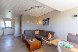 a living room with a couch and a table at Hus-Pellworm-2-Ferienwohnung-Meereswelle in Pellworm